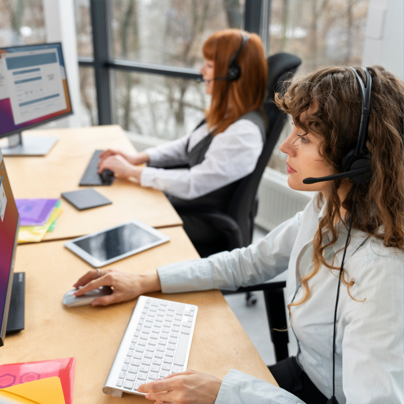 Customer support staff wearing headsets and working at computers.