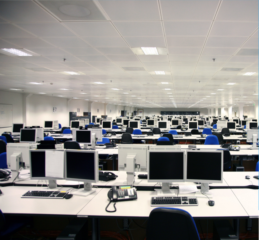 Rows of computer workstations inside a large contact center.