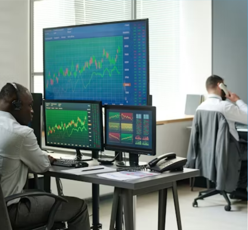 Traders working at desks with financial chart displays.