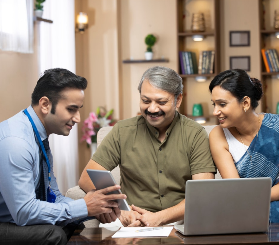 An advisor and two people reviewing information on a tablet and laptop.