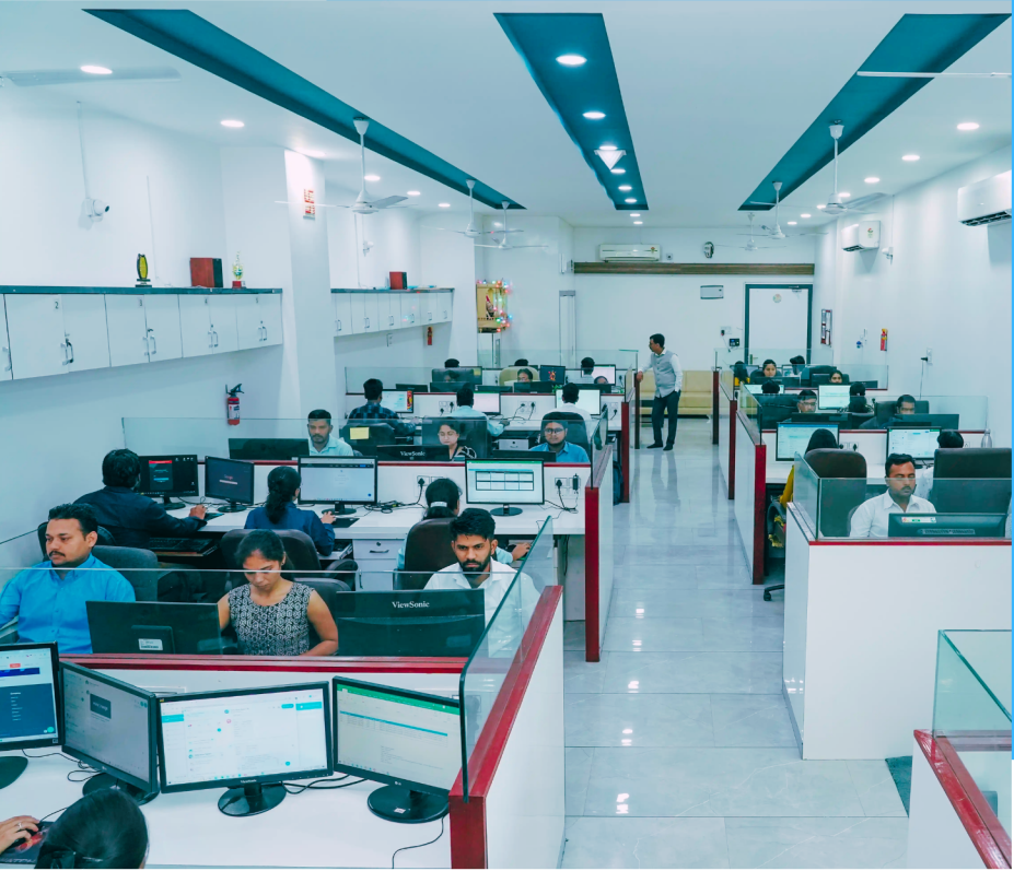 Employees working at computer workstations in a large office.