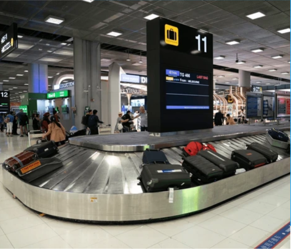 Suitcases circulating on an airport baggage carousel.